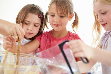 Three Girls Making Cupcakes In Kitchen