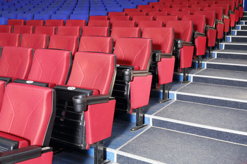 Rows of red and blue seats and stairs in auditorium in cinema