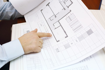 Hands of man looking drawings of apartment