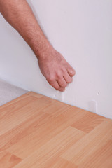 Man using plastic wedges whilst laying parquet