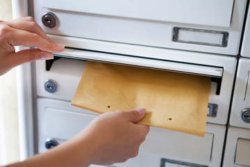 Woman putting envelope in mailbox