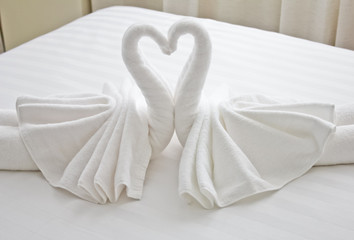 swans made from towels on the bed.