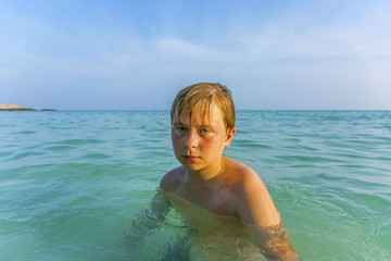 angry young boy in the beautiful ocean