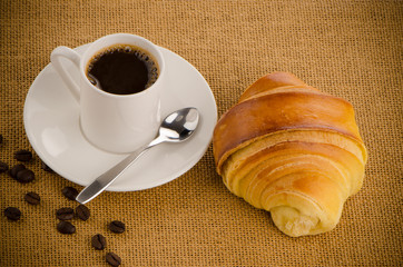 Cup of black coffee and croissant