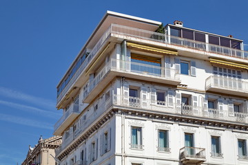 Fototapeta na wymiar Immeuble blanc avec terrasse, ciel bleu
