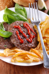 hamburger con ketchup e contorno di patate fritte