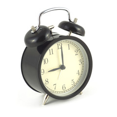 Alarm clock in the black case shows 9 hours isolated on white