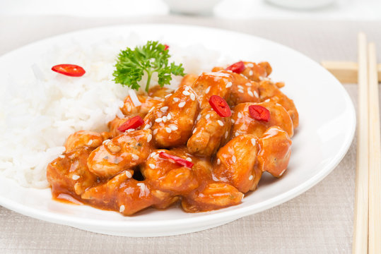 chicken fillet in tomato sauce with sesame seeds, rice close-up