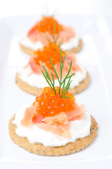 crackers with cream cheese, salted salmon and red caviar closeup