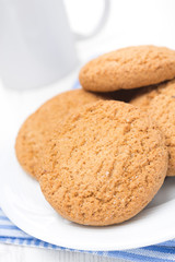 oatmeal cookies on a plate and cup of milk, close-up