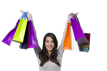 Jubilant woman holding aloft shopping bags