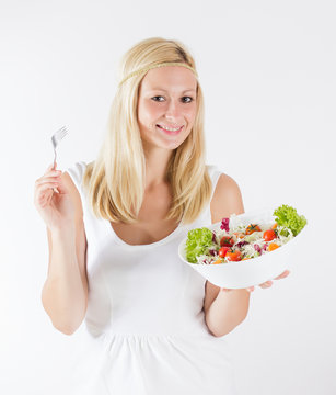happy young woman eating fresh vegetable