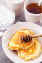 Pancakes with honey served for breakfast. Shallow DOF