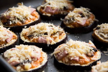 Slice of fried aubergines with tomato sauce, mushrooms, ham and