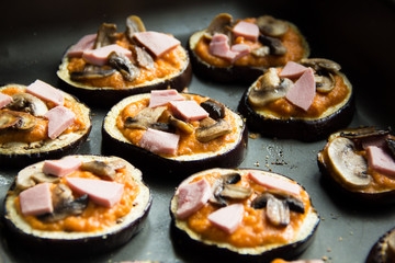 Slice of fried aubergines with tomato sauce, mushrooms and ham