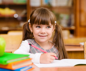 girl drawing in copybook in classroom