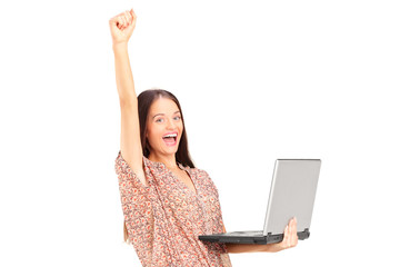 Happy woman holding a laptop with raised hand