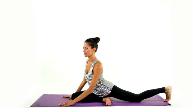 young woman practices yoga moves and positions in a studio