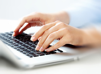 Hands with laptop computer keyboard.
