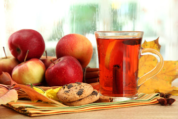 cup of hot tea and autumn leaves, on wooden table