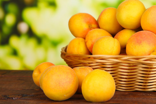 Fresh natural apricot in wicker basket on wooden table