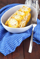 Flavored boiled corn on  plate on wooden table close-up
