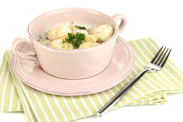 Tender young potatoes with sour cream and herbs in pan isolated