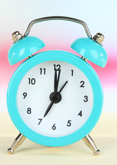 alarm clock on table on light background