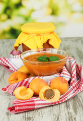 Apricot jam in glass bowl and fresh apricots,