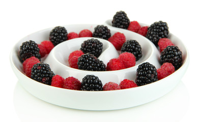 Ripe raspberries and blackberries in plate isolated on white