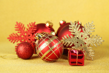 Christmas balls and small gift on yellow background