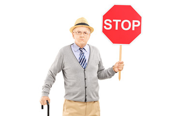 Angry mature gentleman holding a stop sign