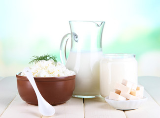 Fresh dairy products on wooden table on natural background