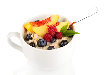 Oatmeal in cup with berries isolated on white