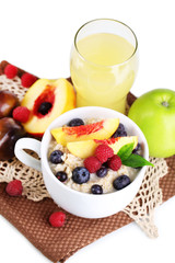 Oatmeal in cup with berries on napkins isolated on white