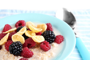 Oatmeal in bowl with berries isolated on white