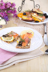 Salmon sandwiches on plate  on wooden table close-up