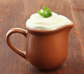 Sour cream in pitcher on table close-up