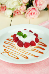 Tasty meringue cake with berries on wooden table