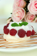 Tasty meringue cake with berries on table