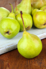 Pears on cutting board, on wooden background