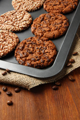 Homemade cookies on dripping pan, on wooden background