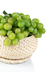 Ripe green grapes in basket isolated on white