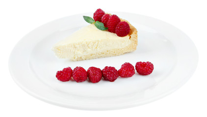 Slice of cheesecake with raspberry on plate, isolated on white