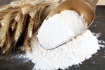 The wholemeal flour in scoop on wooden table