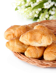 Tasty croissants on wicker mat isolated on white