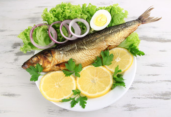 Smoked fish on plate on wooden table