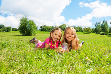 Fototapeta premium Two girls in the grass with butterfly