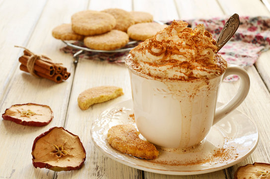 Cup of whipped cream coffee and crumbly cookies