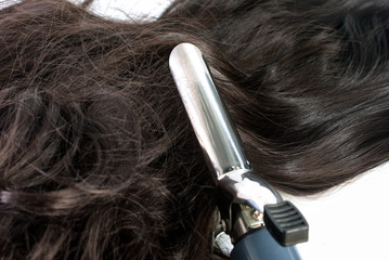 Fototapeta premium Electric curling iron and hair on white background